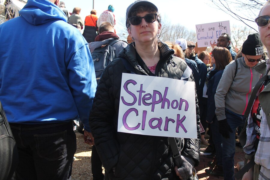 Protester holding a Stephon Clark sign at a rally, Washington DC, March 24, 2018